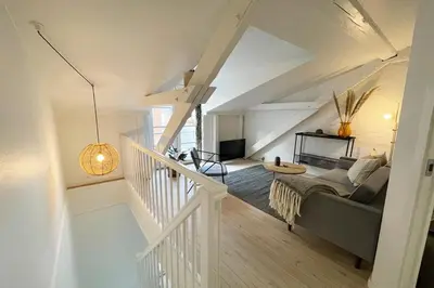 a living room with a couch and a staircase at Cozy Scandinavian Apartment in the Heart of Viborg in Viborg