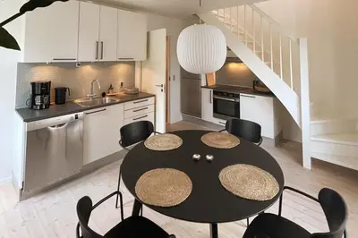 a kitchen and dining room with a table and chairs at Cozy Scandinavian Apartment in the Heart of Viborg in Viborg