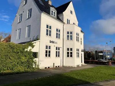 a large white building with a black roof at Modern Scandinavian Apartment in Viborg Centre in Viborg