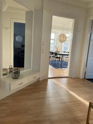 a white room with a wooden floor and a dining room at Modern Scandinavian Apartment in Viborg Centre in Viborg