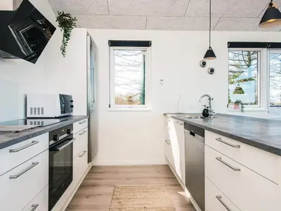 a kitchen with white cabinets and a counter top at 5 star holiday home in Løgstrup in Løgstrup