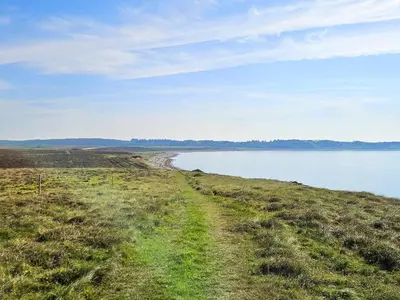 a dirt road next to a body of water at 6 person holiday home in Spøttrup in Spottrup
