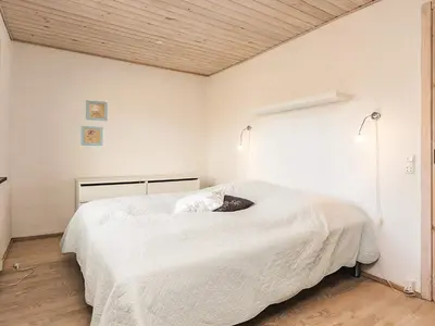 a bedroom with a large white bed with two lights at 6 person holiday home in Spøttrup in Spottrup