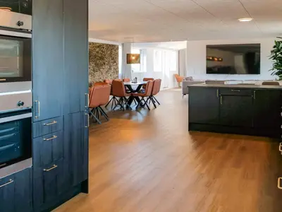 a kitchen and living room with a table and chairs at 5 star holiday home in Blokhus in Blokhus