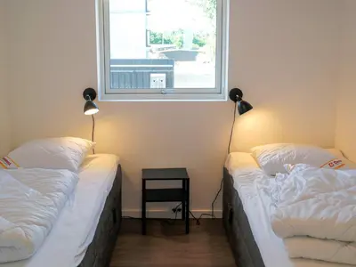 two beds in a room with a window at 5 star holiday home in Blokhus in Blokhus