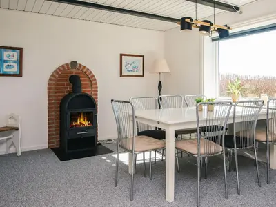 a dining room with a table and a fireplace at 5 person holiday home in Snedsted in Snedsted