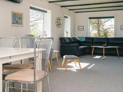 a living room with a couch and a table and chairs at 5 person holiday home in Snedsted in Snedsted
