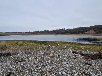 a large body of water with a rocky shore at 4 star holiday home in Spøttrup in Lihme