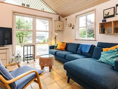 a living room with blue couches and a tv at 4 star holiday home in Spøttrup in Lihme