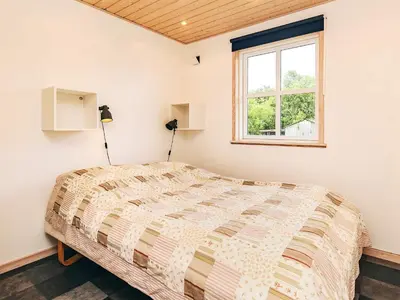 a bedroom with a bed and a window at 4 star holiday home in Spøttrup in Lihme