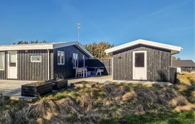 a small house with a deck and a patio at 3 Bedroom Cozy Home In Løkken in Løkken