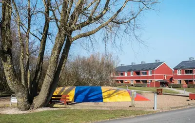 a tent sitting next to a tree next to a street at Cozy Apartment In Lemvig With Sauna in Lemvig