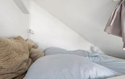 a bed in a bedroom with a white wall at Cozy Apartment In Lemvig With Sauna in Lemvig