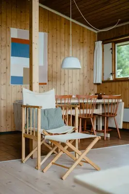 a dining room with a white chair and a table at Warm 70S Vibe Near Limfjord in Løgstør