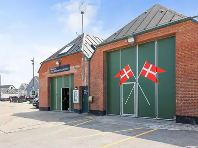 a brick building with two flags on the side of it at 6 person holiday home in Thisted in Thisted