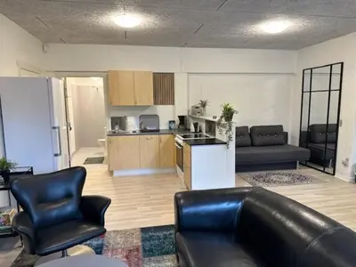 a living room with a couch and chairs and a kitchen at Struer Festcenter - Vest Bowl lejlighed 2 Bredgade 62 A in Struer