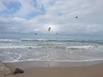 a group of people flying kites over the ocean at 4 star holiday home in Løkken in Løgsted