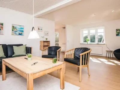 a living room with a table and chairs at 4 star holiday home in Løkken in Løgsted