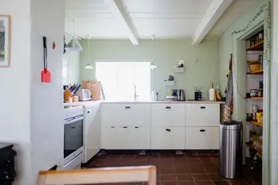 a kitchen with white cabinets and a window at Cut Branches, Make Fire And Gaze At Treetops in Nykøbing Mors