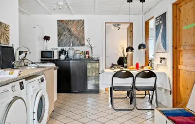 a kitchen with a washing machine and two chairs at Amazing Apartment In Thisted With Wifi in Thisted