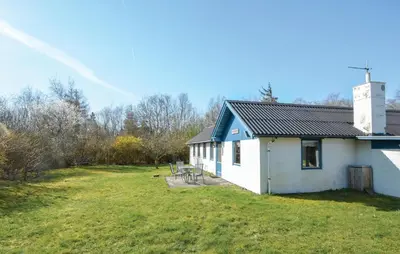 a white building with a group of chairs in a yard at 2 Bedroom Nice Home In Roslev in Roslev
