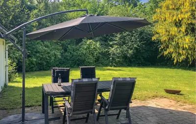 a table with two chairs and an umbrella at 2 Bedroom Nice Home In Roslev in Roslev