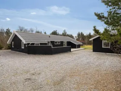 a home with a black house with a gravel driveway at Holiday Home Onni - 2-3km from the sea by Interhome in Saltum