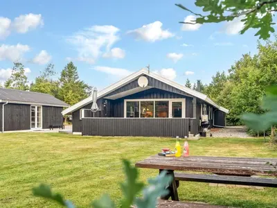 a house with a picnic table in the yard at Holiday Home Onni - 2-3km from the sea by Interhome in Saltum