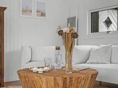 a living room with a table with a vase of flowers at Holiday Home Gundborg - 200m from the sea by Interhome in Saltum
