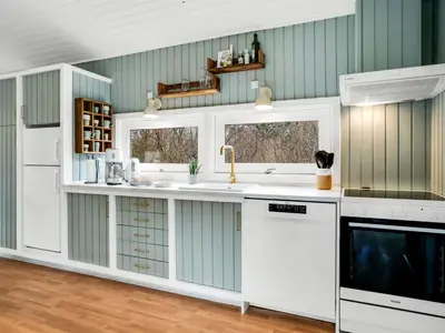 a kitchen with white cabinets and a sink at Holiday Home Gundborg - 200m from the sea by Interhome in Saltum