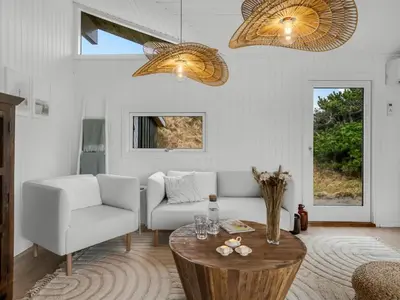 a living room with a couch and a table at Holiday Home Gundborg - 200m from the sea by Interhome in Saltum