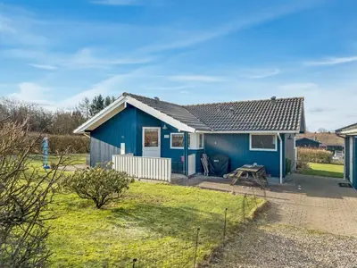 a blue house with a picnic table in a yard at Holiday Home Anline - 600m to the fjord by Interhome in Farsø