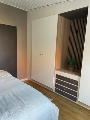a bedroom with a bed and a cabinet with a potted plant at Stor lys lejlighed på 100 kvm, central beliggenhed in Holstebro