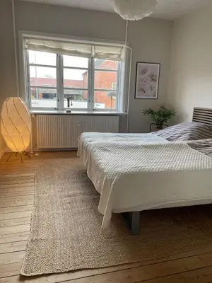 a bedroom with a large bed and a window at Stor lys lejlighed på 100 kvm, central beliggenhed in Holstebro