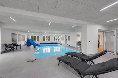 a pool with chairs and a slide in a house at Exclusive Pool Houseconference Center With Gymnasium in Erslev