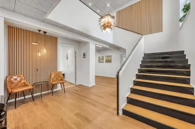 a staircase in a living room with two chairs at Exclusive Pool Houseconference Center With Gymnasium in Erslev