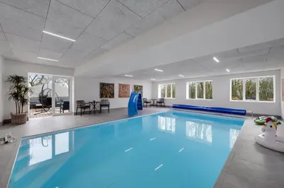 a large swimming pool with blue lighting in a building at Exclusive Pool Houseconference Center With Gymnasium in Erslev