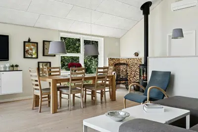 a living room with a table and chairs at Forest House With Stream By Hjarbæk Fjord in Højslev