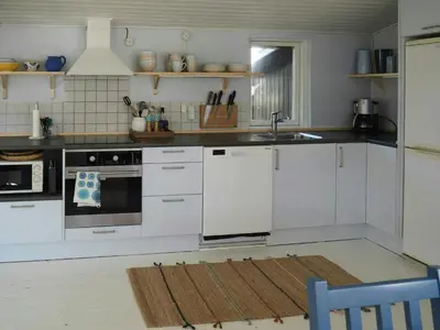 a kitchen with white cabinets and a sink at Traditional Holiday Home At Cold Hawaii in Torsted