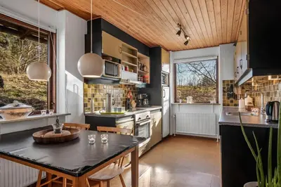 a kitchen with a black counter top and a table at Cozy Holiday Home Near Lild Strand in Frøstrup