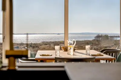 a table with chairs and a view of the water at Lovely Holiday Home With Panoramic View Of The Fjord in Amtoft