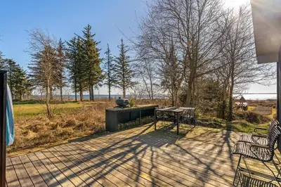 a patio with a grill and a table and chairs at Lovely Holiday Home With Panoramic View Of The Fjord in Amtoft