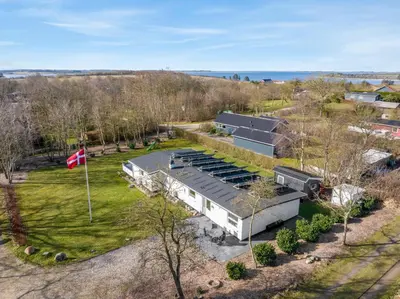 an aerial view of a building with a flag at Holiday Home With Pool And Spa Close To The Limfjord in Roslev
