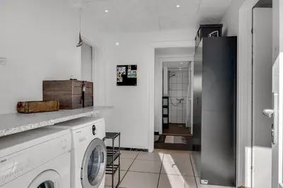 a white laundry room with a washer and dryer at Holiday Home With Pool And Spa Close To The Limfjord in Roslev