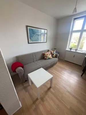 a living room with a couch and a table at Cozy base near the cathedral in Viborg