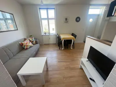 a living room with a couch and a table at Cozy base near the cathedral in Viborg