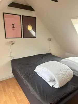 a bed in a bedroom with two pictures on the wall at Svane's Air-bnb in Nykøbing Mors
