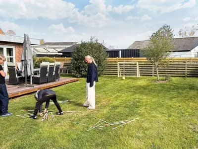 two people playing with sticks in a yard at 4 star holiday home in Løgstør in Løgsted