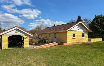 a yellow house with a garage in a yard at Stunning Home In Farsø With Wifi in Farsø