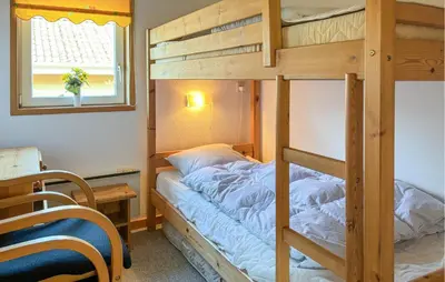 a bedroom with bunk beds with a desk and a window at Stunning Home In Farsø With Wifi in Farsø